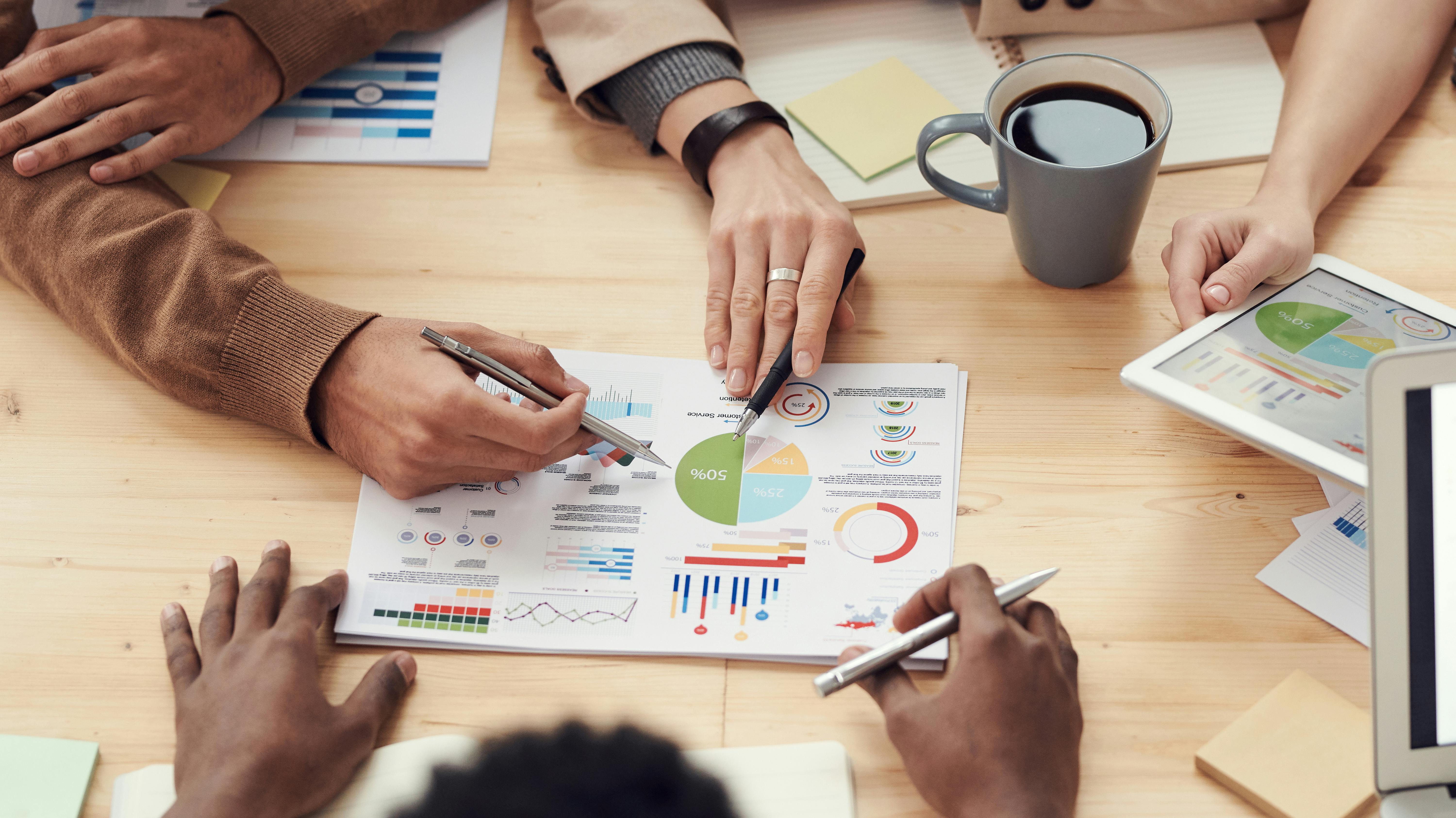 Co-workers planning a project with charts and graphs on a table